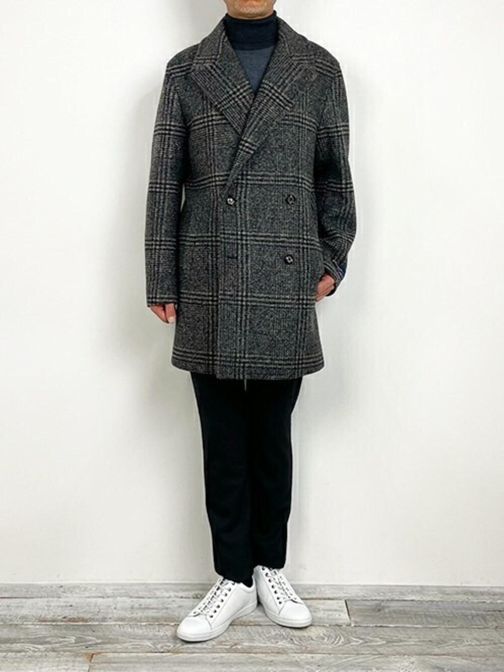 グレー系のチェスターコート、グレー系のその他パンツ、ホワイト系のスニーカーを着用したメンズの冬コーディネートの1枚目の写真