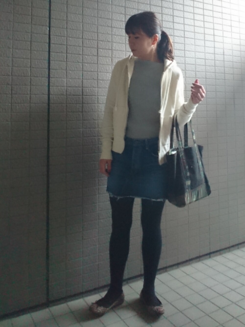 ブラック系のトートバッグ、ホワイト系のパーカー、グレー系のTシャツ/カットソーを着用したレディースの秋コーディネートの1枚目の写真