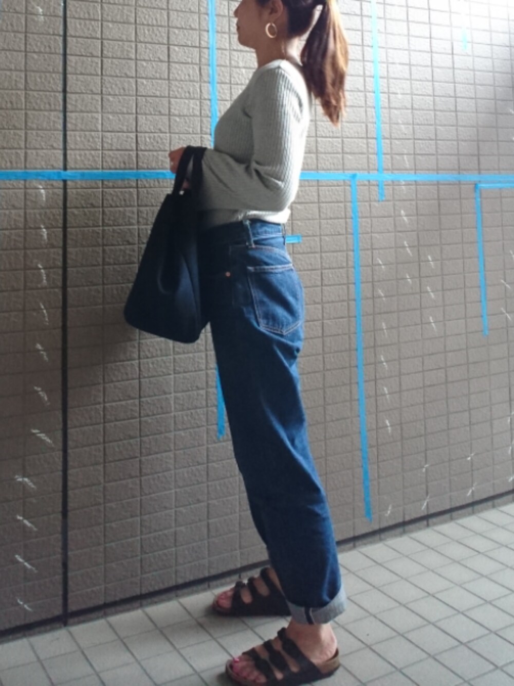 グレー系のTシャツ/カットソー、ブルー系のデニムパンツ、ブルー系のトートバッグを着用したレディースの春コーディネートの1枚目の写真