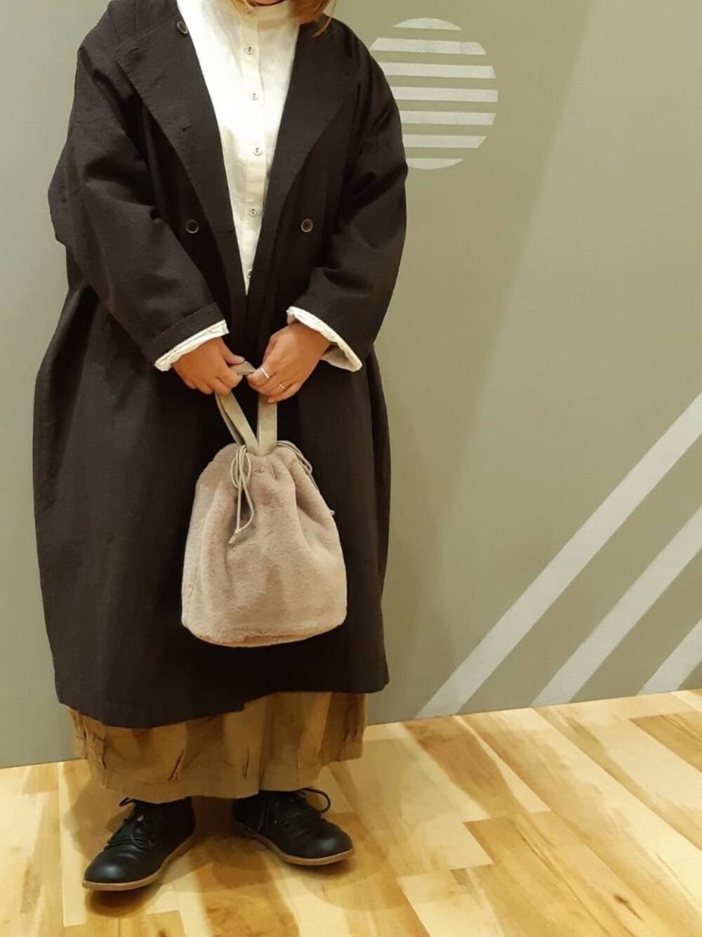 ブラック系のその他アウター、ブラウン系のハンドバッグ、ブラウン系のその他パンツを着用したレディースの秋コーディネートの1枚目の写真