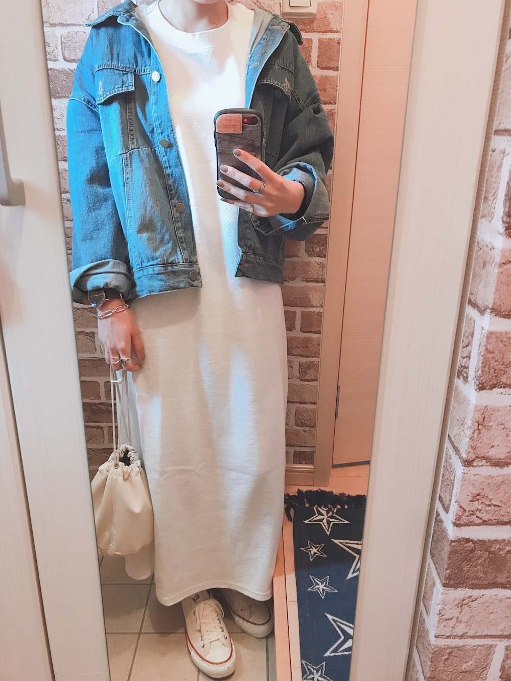 ホワイト系のスニーカー、ホワイト系のワンピース、ブルー系のデニムジャケットを着用したレディースの春コーディネートの1枚目の写真