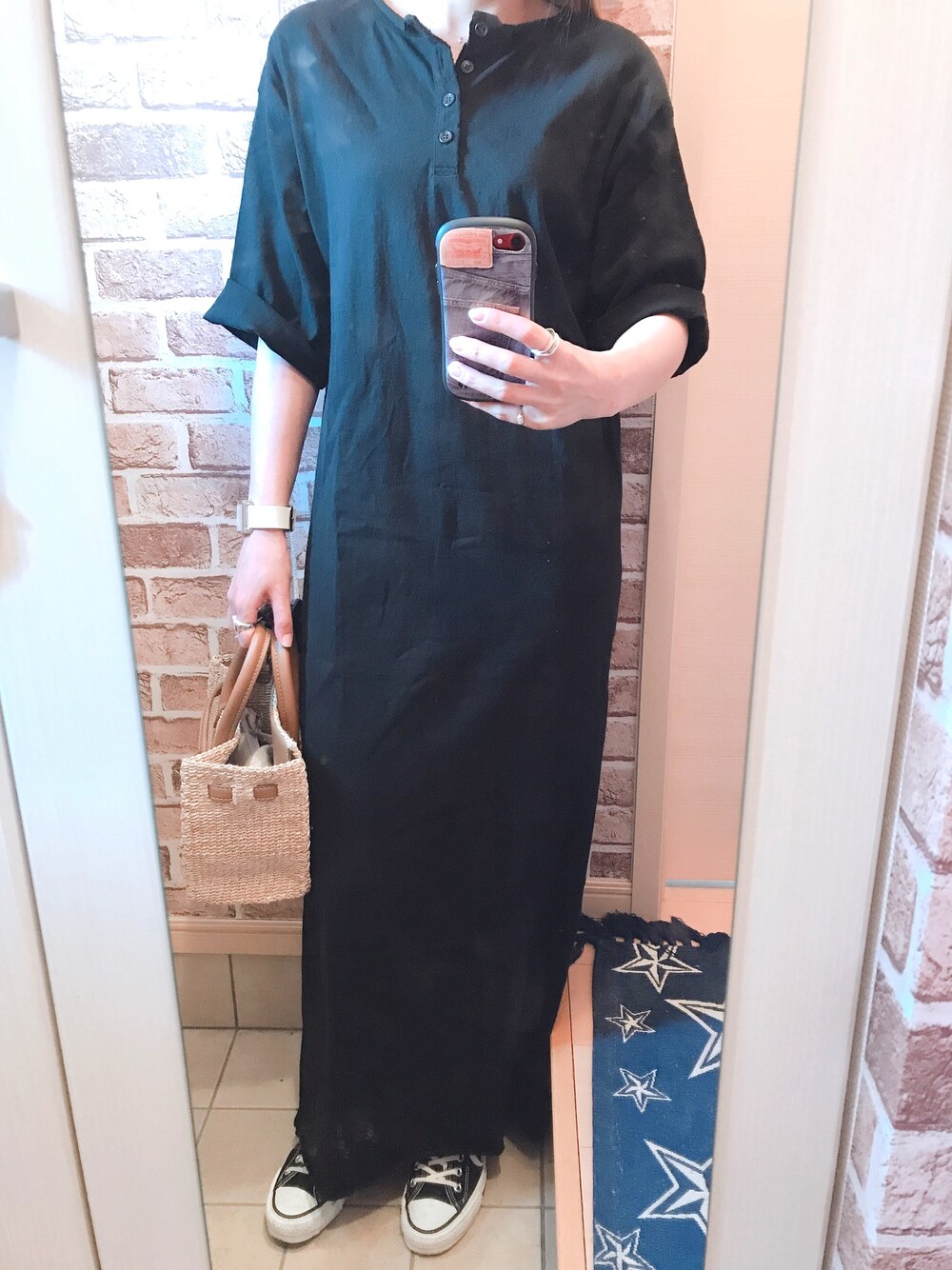 ブラック系のスニーカー、ブラック系のワンピース、ベージュ系のかごバッグを着用したレディースの春コーディネートの1枚目の写真