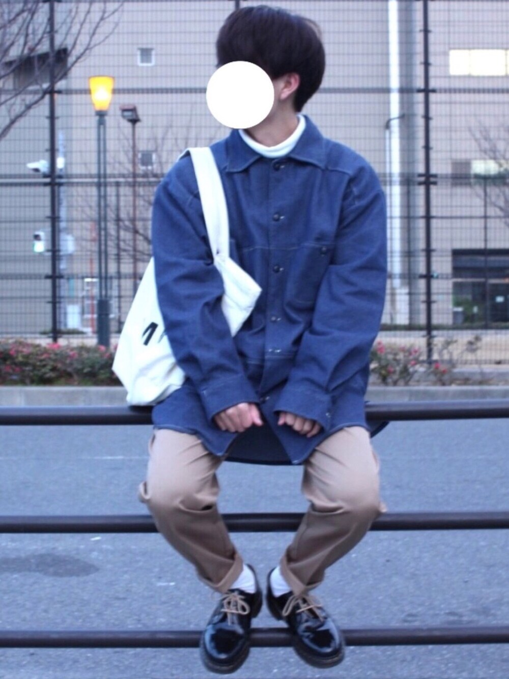 ブルー系のデニムジャケット、ホワイト系のニット/セーター、ホワイト系のトートバッグを着用したメンズの冬コーディネートの1枚目の写真