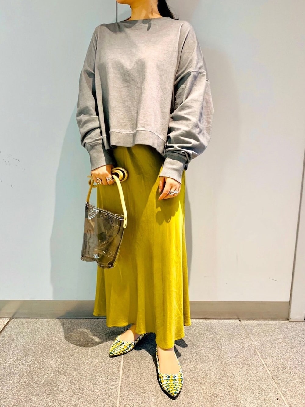 イエロー系のスカート、その他のパンプス、その他のショルダーバッグを着用したレディースの春コーディネートの1枚目の写真