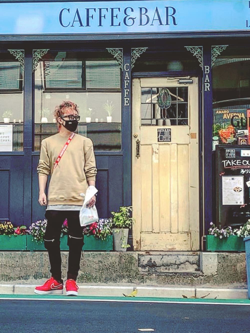 レッド系のショルダーバッグ、ベージュ系のスウェット、ブラック系のその他パンツを着用したメンズの春コーディネートの1枚目の写真