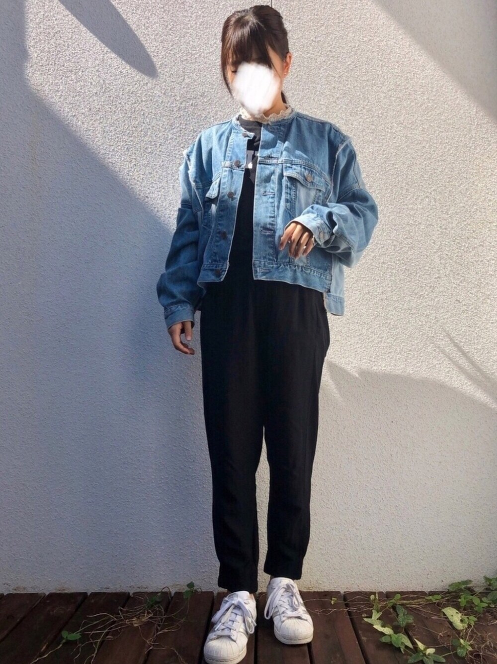 ブルー系のデニムジャケット、ブラック系のその他パンツ、ホワイト系のスニーカーを着用したレディースの秋コーディネートの1枚目の写真