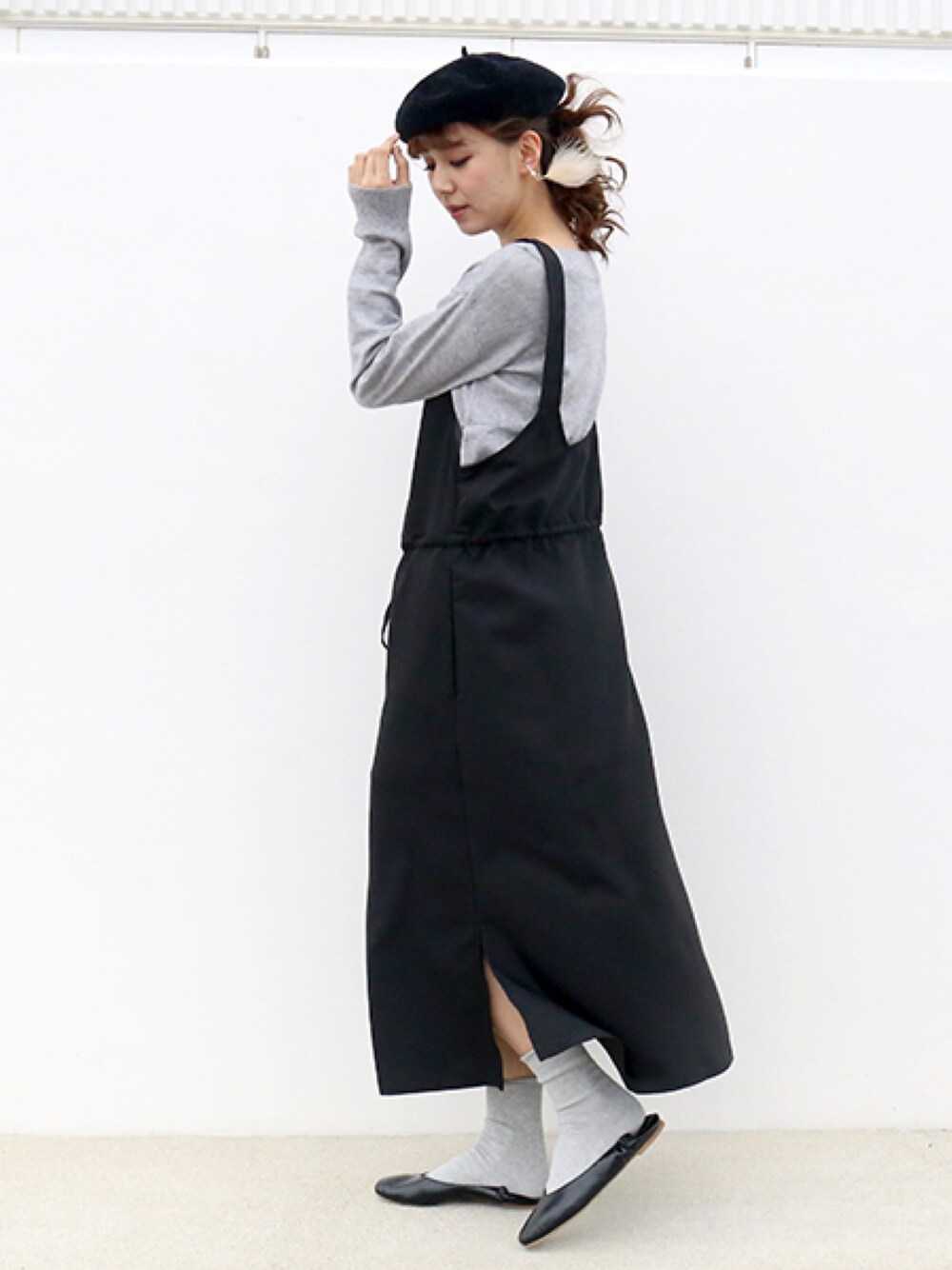 ブラック系のジャンパースカート、グレー系のニット/セーター、ブラック系のハンチング/ベレー帽を着用したレディースの秋コーディネートの1枚目の写真