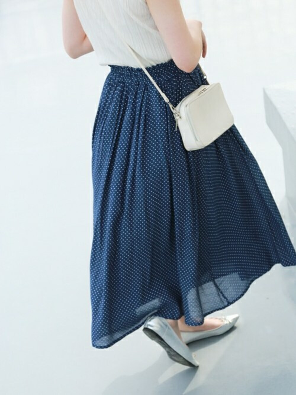 ブルー系のスカートを着用したレディースの春コーディネートの1枚目の写真