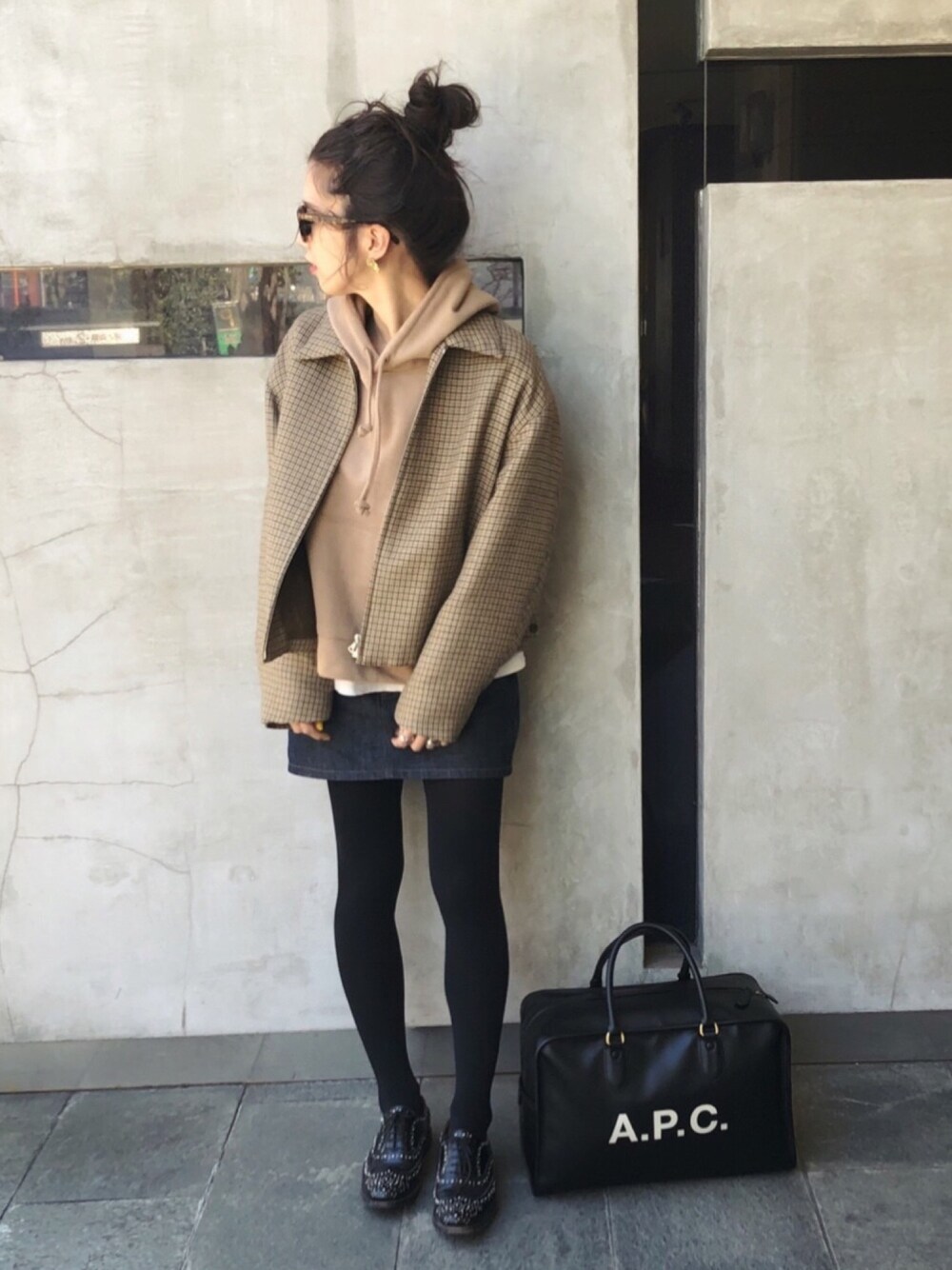 ベージュ系のブルゾン、ベージュ系のパーカー、ブルー系のデニムスカートを着用したレディースの冬コーディネートの1枚目の写真