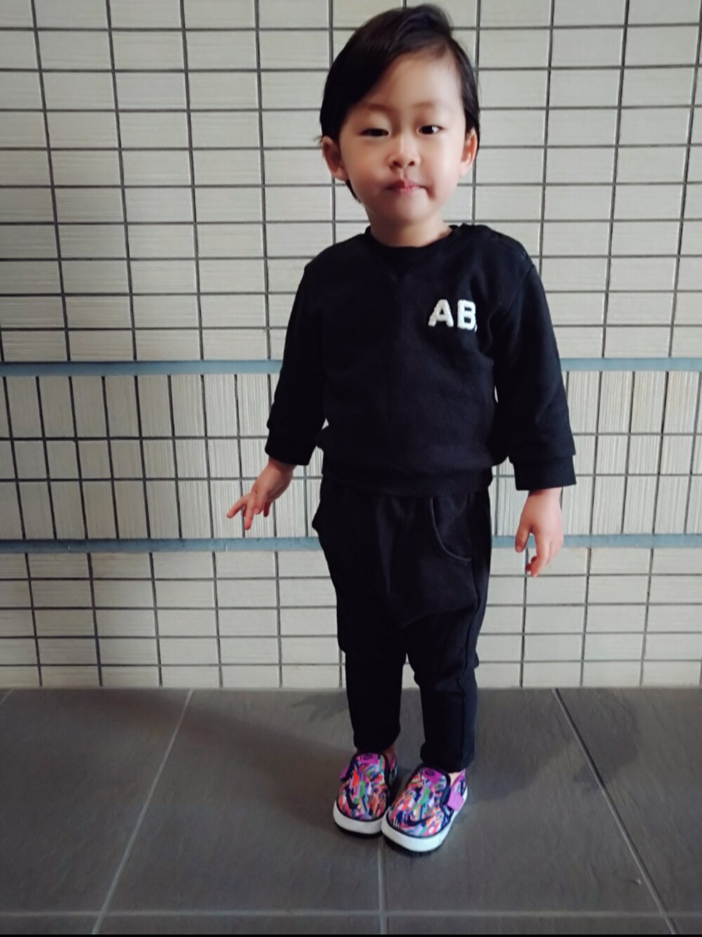 「黒コーデ、保育園コーデ、保育園スタイル、スエット、スリッポン、サルエルパンツ、黒、NIKE、登園スタイル、2歳」｜「NIKEのキッズ NIKE ナイキ TOKI SLIPON CVS PR(TDV) トキ スリッポン キャンバス プリント TDV 719738-502 502HVIL/PRPLDY（スリッポン、その他）」を使った、エトさん（キッズ・80cm）の春コーディネートの1枚目の写真