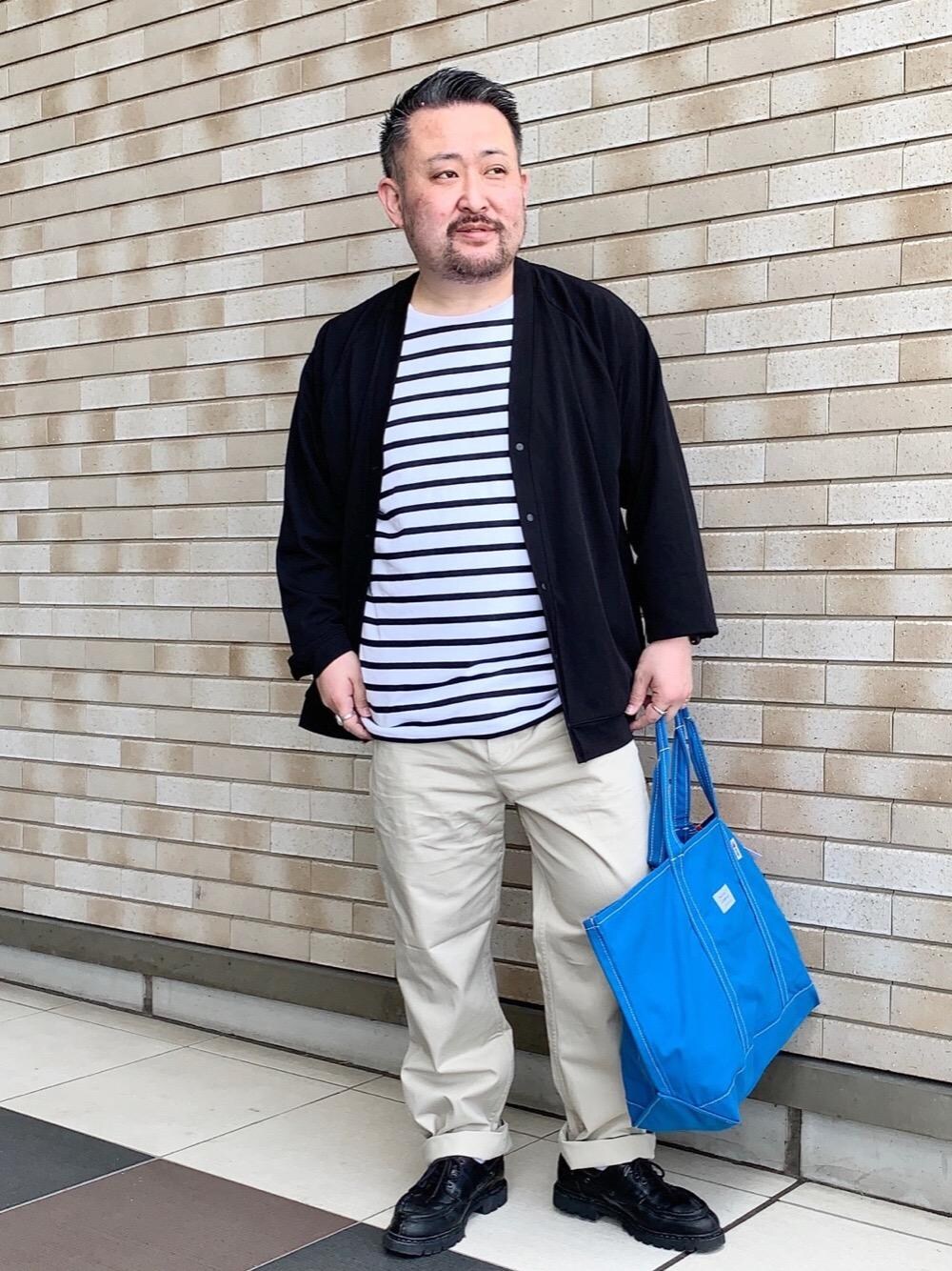 ブラック系のTシャツ/カットソー、ブラック系のカーディガン/ボレロ、ブルー系のトートバッグを着用したメンズの春コーディネートの1枚目の写真