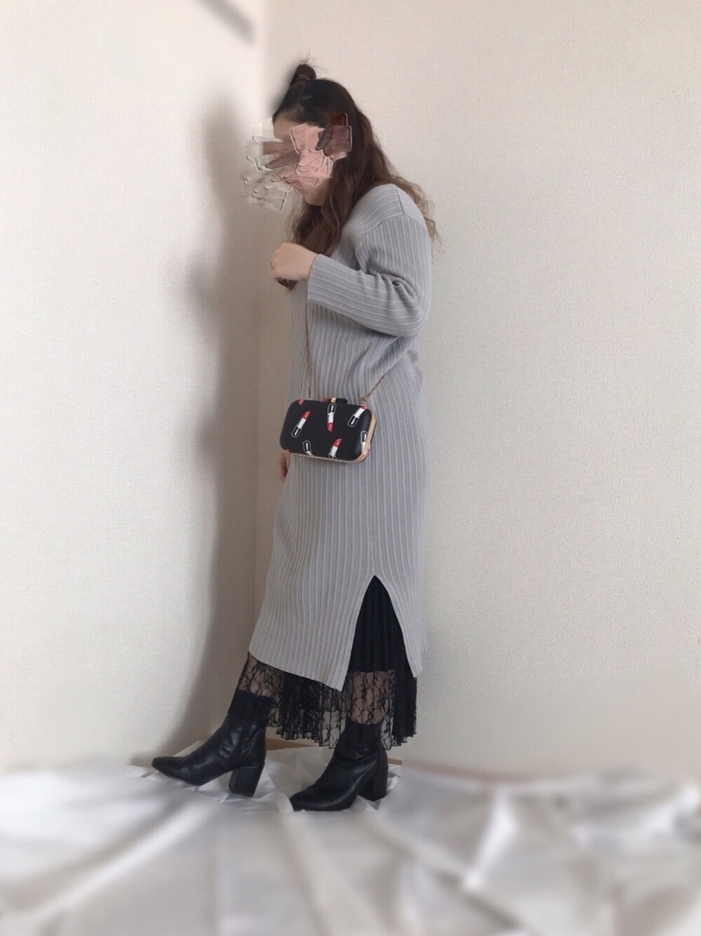 グレー系のワンピース、ブラック系のスカート、ブラック系のブーツを着用したレディースの春コーディネートの1枚目の写真
