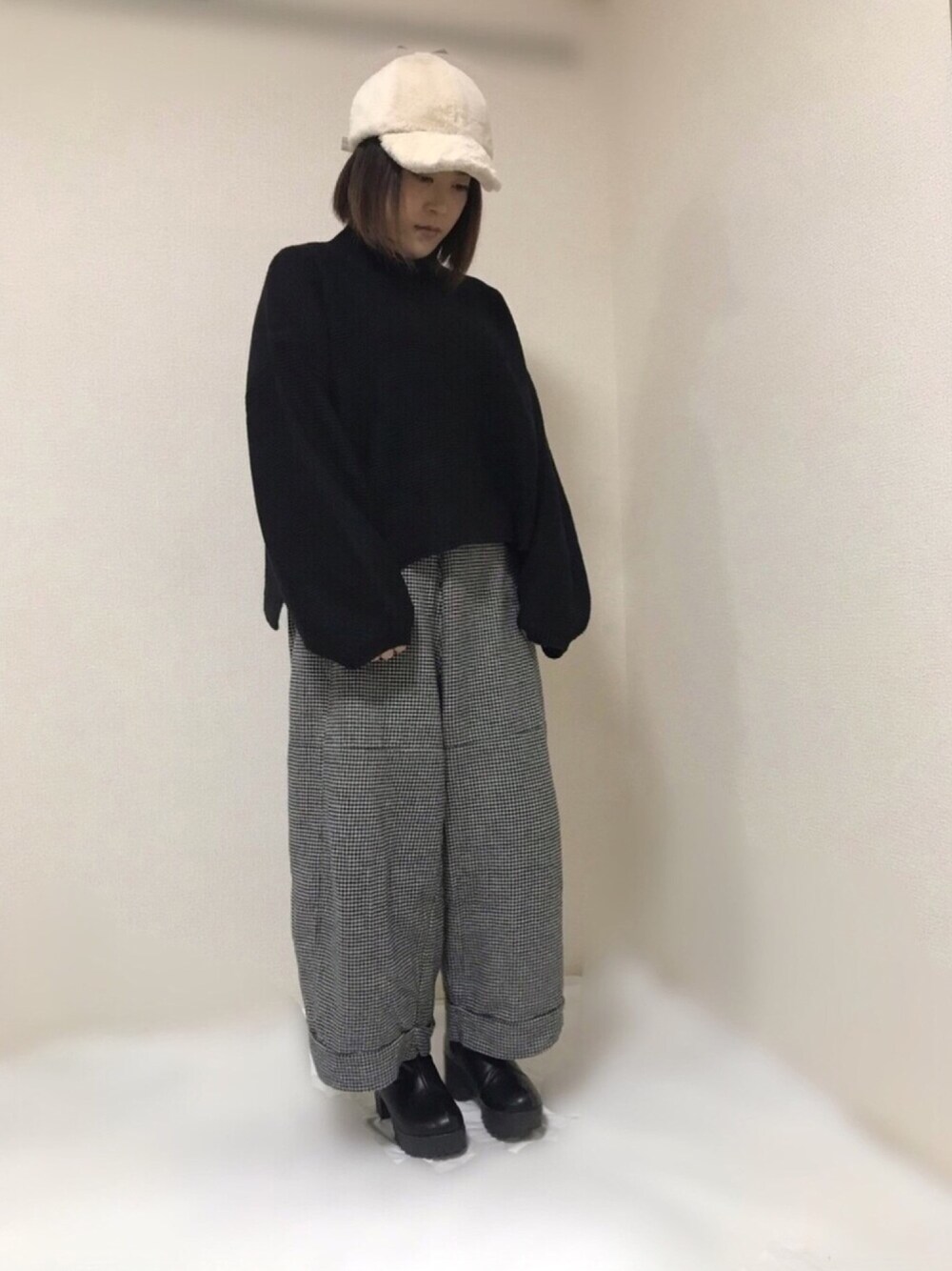 ブラック系のニット/セーター、ホワイト系のその他パンツ、ブラック系のブーツを着用したレディースの秋コーディネートの1枚目の写真