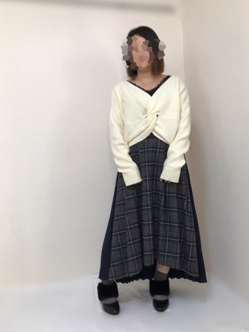 ホワイト系のニット/セーター、ブラック系のTシャツ/カットソー、ブルー系のスカートを着用したレディースの冬コーディネートの1枚目の写真