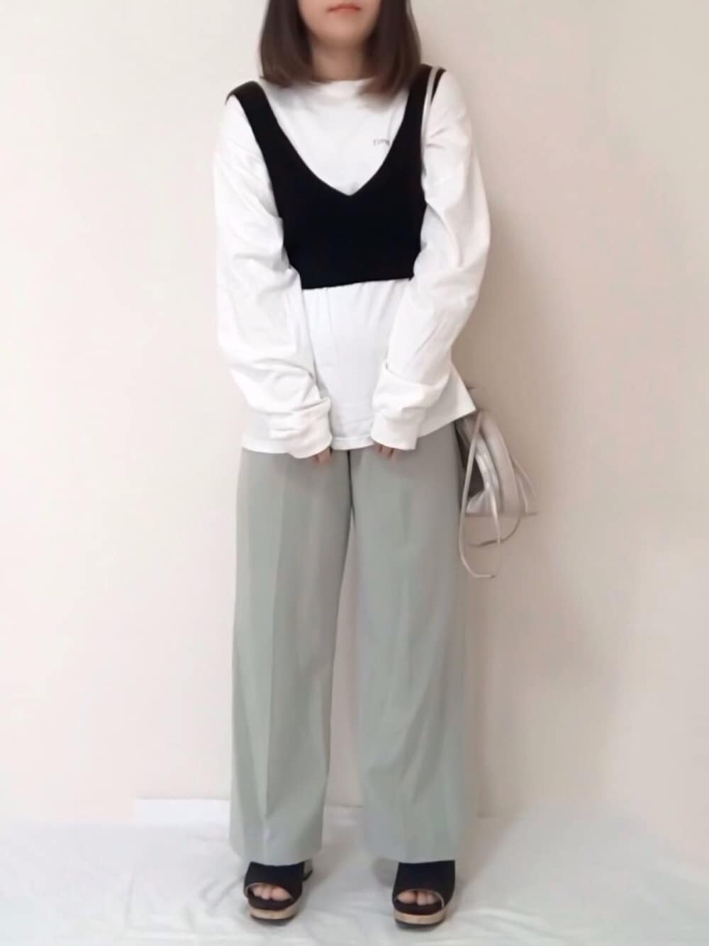 ホワイト系のTシャツ/カットソー、グリーン系のパンツ、ホワイト系のバッグを着用したレディースの春コーディネートの1枚目の写真