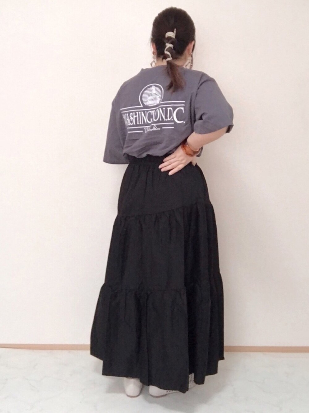 グレー系のTシャツ/カットソー、ブラック系のスカート、ホワイト系のパンプスを着用したレディースの夏コーディネートの1枚目の写真
