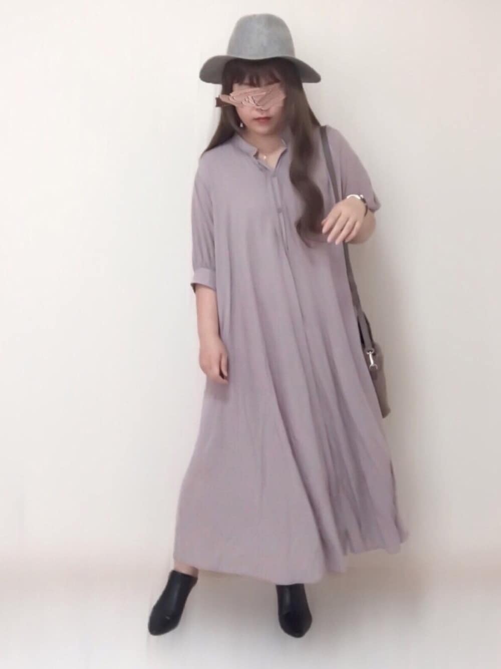 グレー系のワンピース、ベージュ系のバッグ、ブラック系のシューズを着用したレディースの秋コーディネートの1枚目の写真