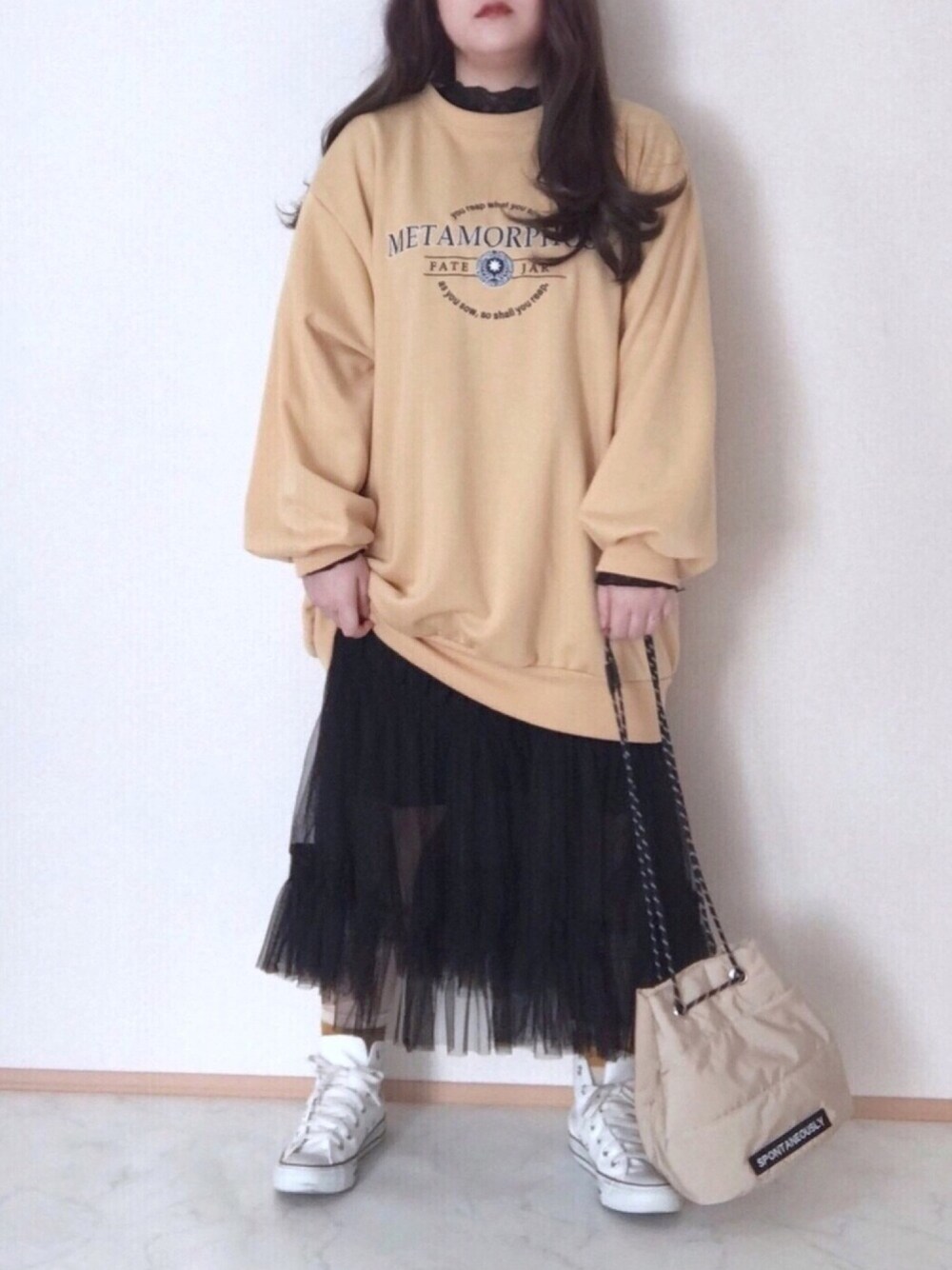 ブラック系のTシャツ/カットソー、イエロー系のスウェット、ブラック系のスカートを着用したレディースの冬コーディネートの1枚目の写真