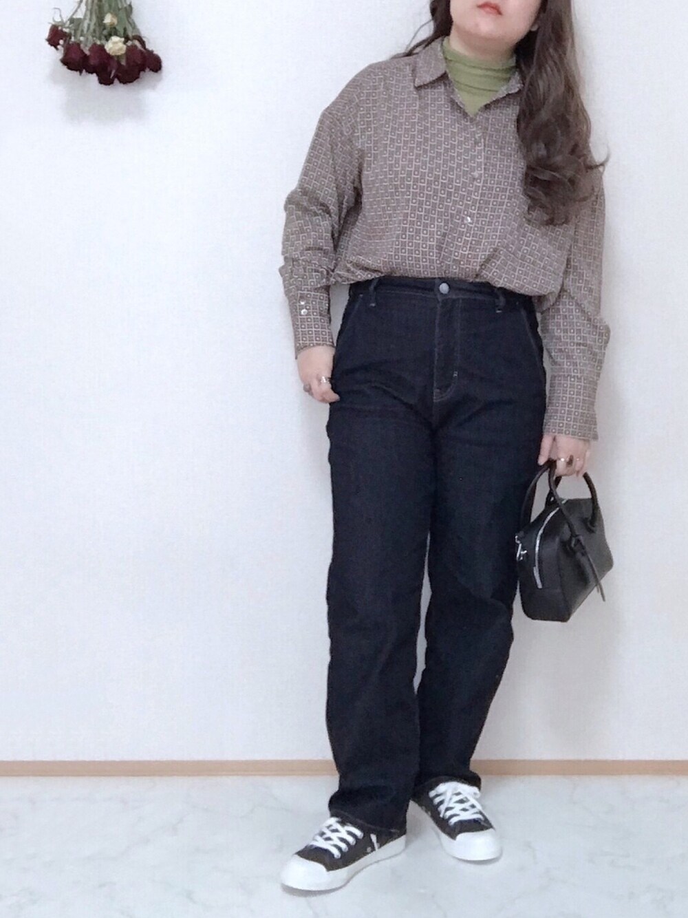 グリーン系のニット/セーター、グレー系のシャツ/ブラウス、ブルー系のデニムパンツを着用したレディースの春コーディネートの1枚目の写真