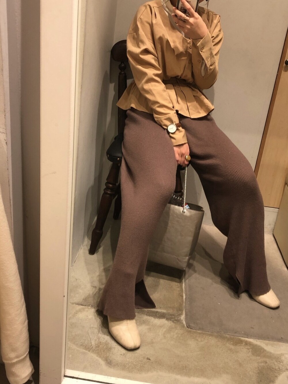 ブラック系のシャツ/ブラウス、ブラウン系のパンツ、ホワイト系のブーツを着用したレディースの冬コーディネートの1枚目の写真