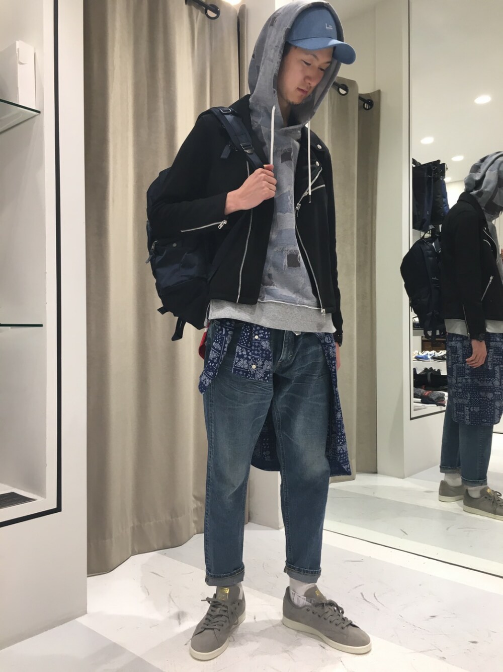 グレー系のパーカー、ブラック系のライダースジャケット、ブルー系のデニムパンツを着用したメンズの冬コーディネートの1枚目の写真