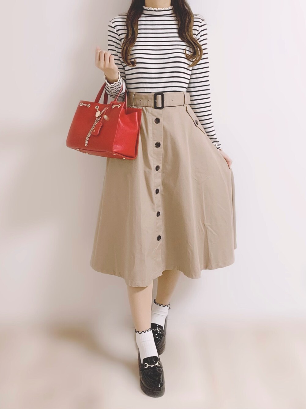 ホワイト系のTシャツ/カットソー、ベージュ系のスカート、ブラック系のローファーを着用したレディースの春コーディネートの1枚目の写真