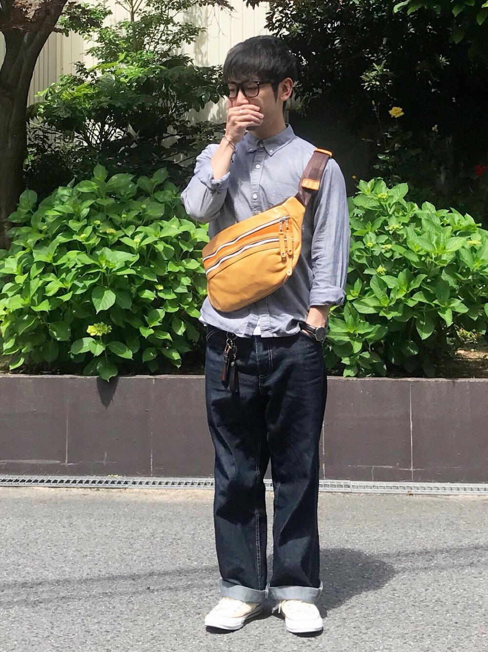 グレー系のシャツ/ブラウス、ブルー系のデニムパンツ、イエロー系のボディバッグ/ウエストポーチを着用したメンズの春コーディネートの1枚目の写真