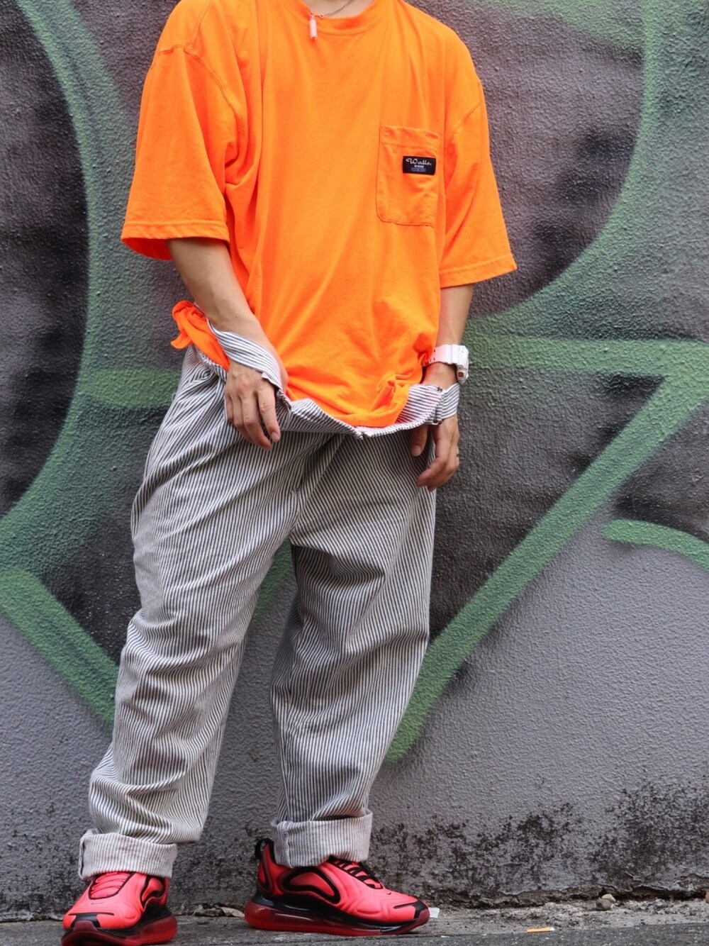 レッド系のスニーカー、ホワイト系のサロペット/オーバーオール、オレンジ系のTシャツ/カットソーを着用したメンズの夏コーディネートの1枚目の写真