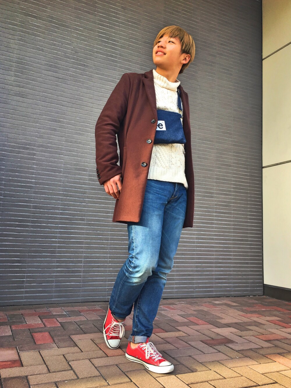 ブルー系のショルダーバッグ、ホワイト系のニット/セーター、ブルー系のデニムパンツを着用したメンズの冬コーディネートの1枚目の写真