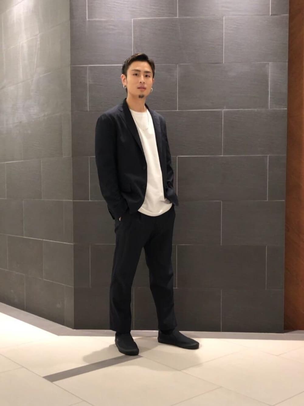 ブラック系のスニーカー、ブルー系のその他パンツ、ブルー系のテーラードジャケットを着用したメンズの春コーディネートの1枚目の写真