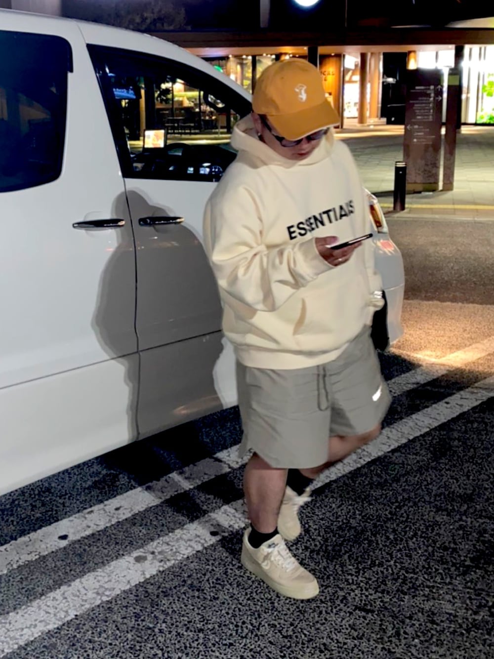 ベージュ系のパーカー、グレー系のパンツ、ベージュ系のスニーカーを着用したメンズの冬コーディネートの1枚目の写真