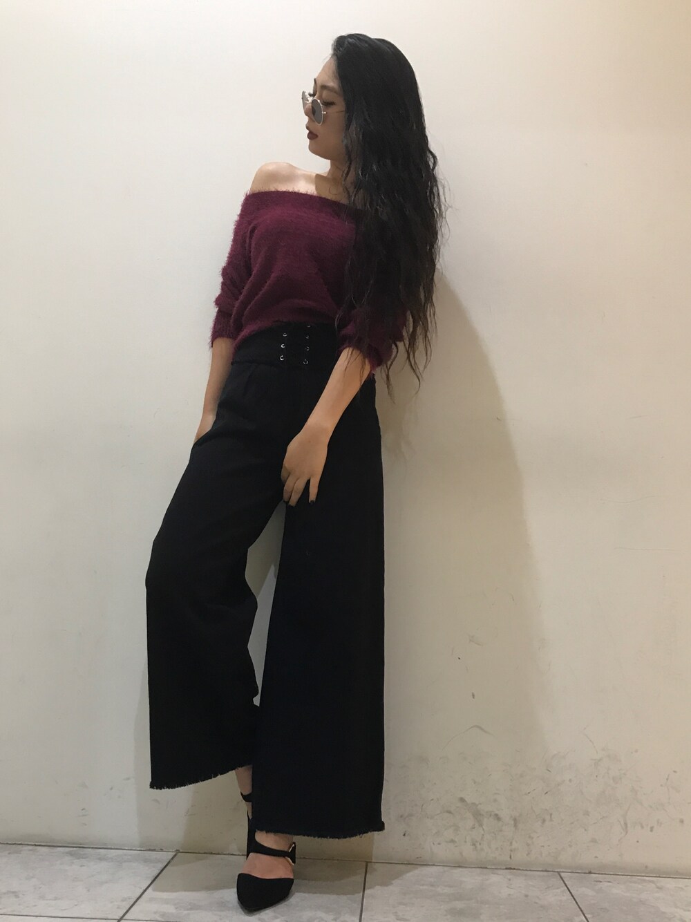 ブラック系のデニムパンツ、レッド系のニット/セーター、ブラック系のパンプスを着用したレディースの秋コーディネートの1枚目の写真