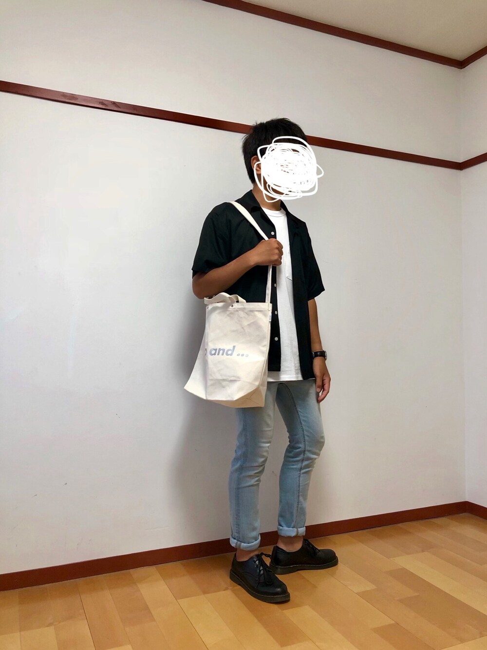 ホワイト系のトートバッグ、ブラック系のドレスシューズ、ブルー系のデニムパンツを着用したメンズの夏コーディネートの1枚目の写真