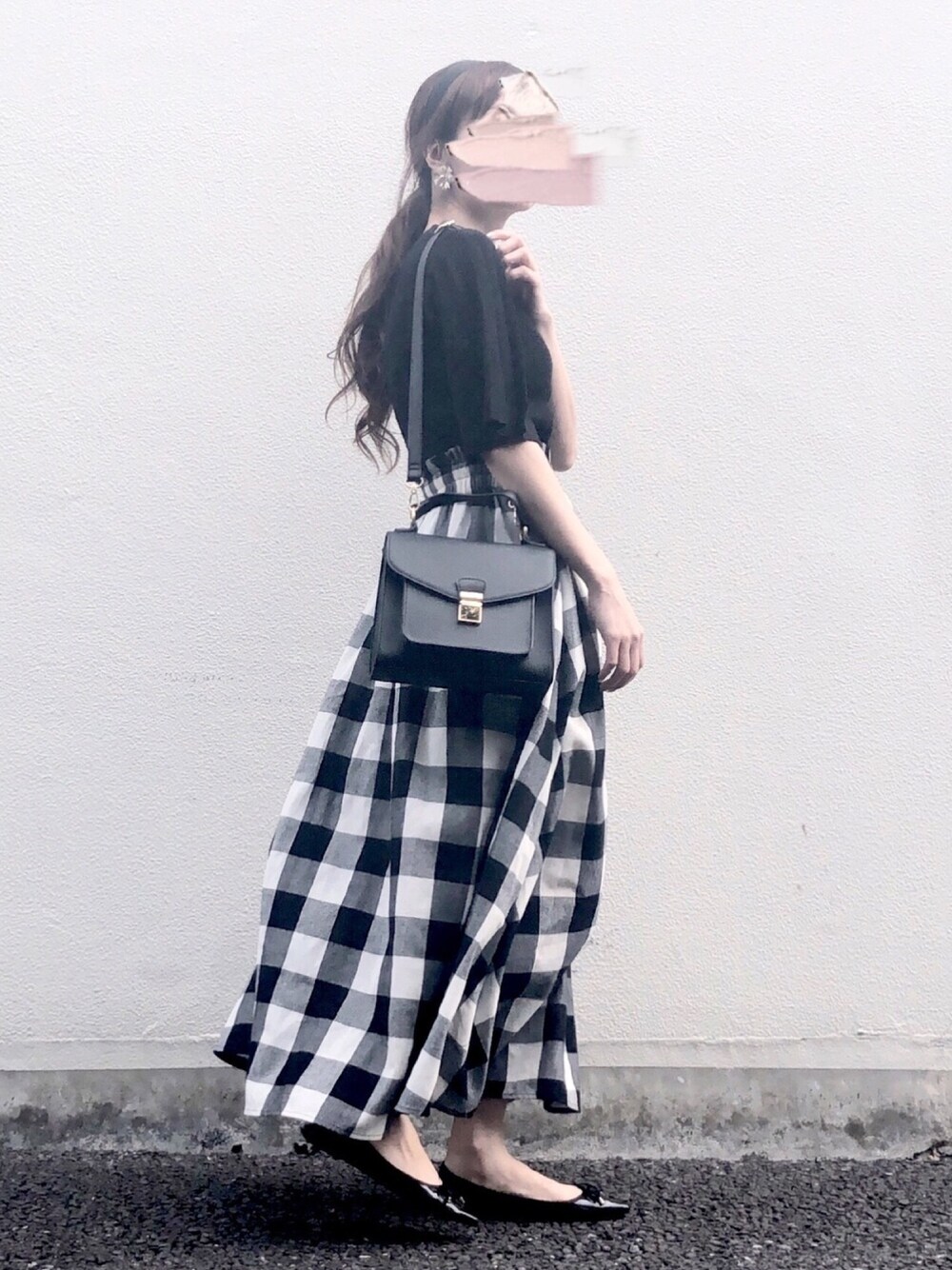 ブラック系のニット/セーター、ブラック系のスカート、ブラック系のパンプスを着用したレディースの春コーディネートの1枚目の写真