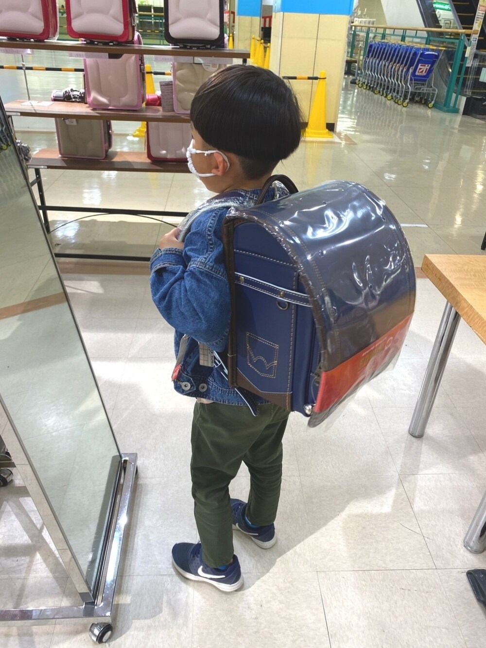 ブルー系のデニムジャケット、ブルー系のスニーカー、ブルー系のランドセルを着用したキッズの春コーディネートの1枚目の写真