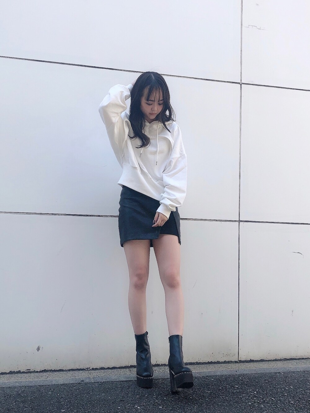 ホワイト系のパーカー、ブラック系のスカート、ブラウン系のブーツを着用したレディースの夏コーディネートの1枚目の写真