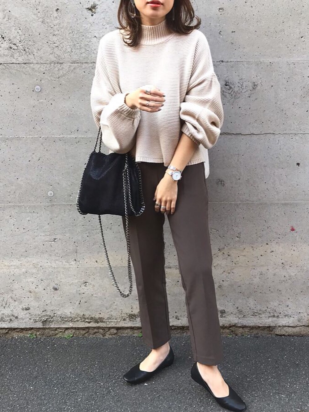 ブラック系のパンプス、ブラック系のショルダーバッグを着用したレディースの冬コーディネートの1枚目の写真