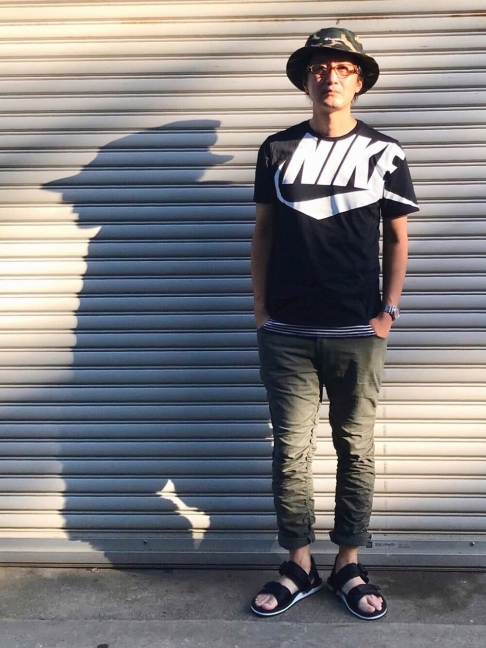 ブラック系のTシャツ/カットソー、ホワイト系のタンクトップ、グリーン系のチノパンツを着用したメンズの夏コーディネートの1枚目の写真