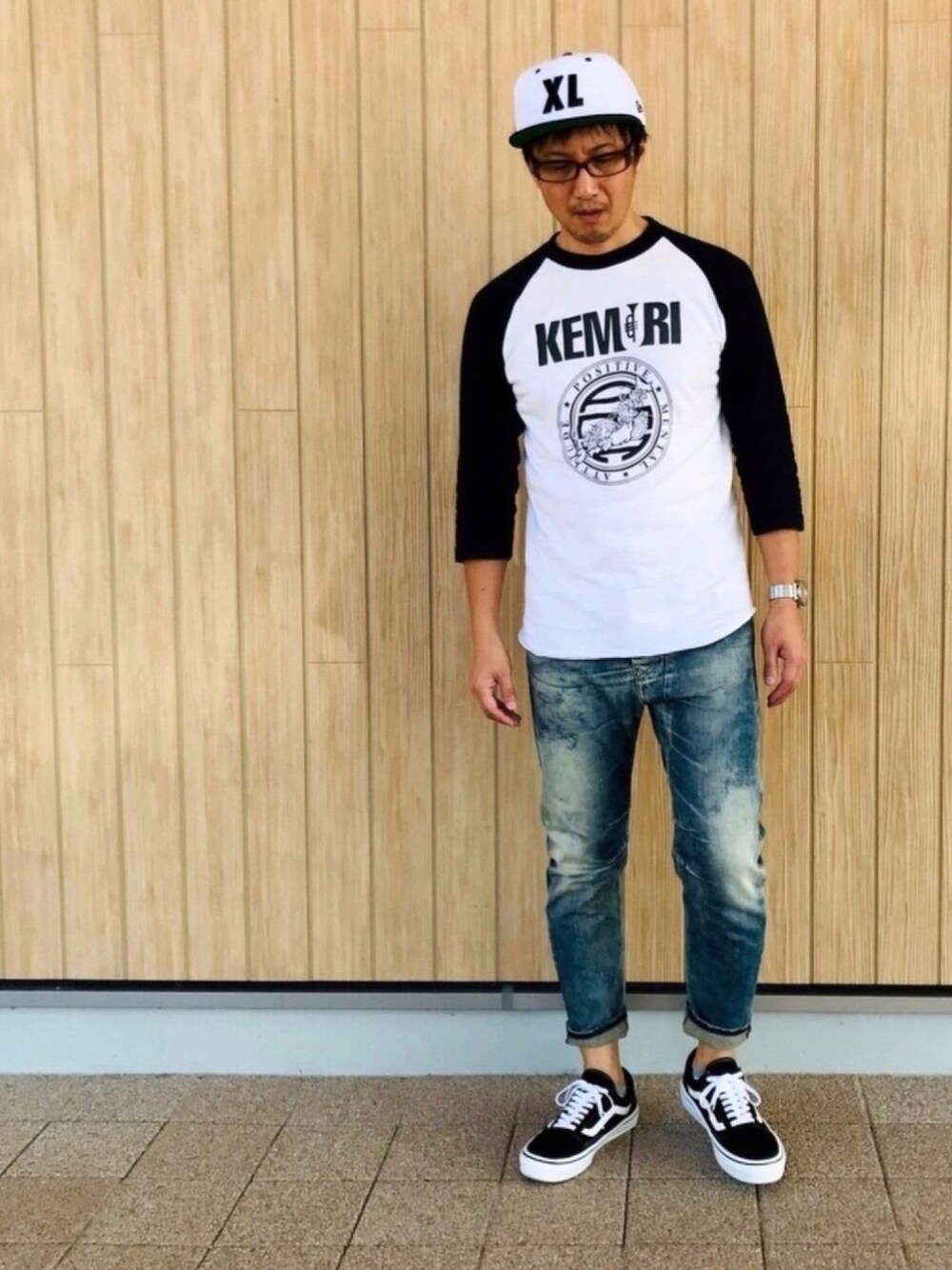 ホワイト系のTシャツ/カットソー、ブルー系のデニムパンツ、ブラック系のスニーカーを着用したメンズの秋コーディネートの1枚目の写真