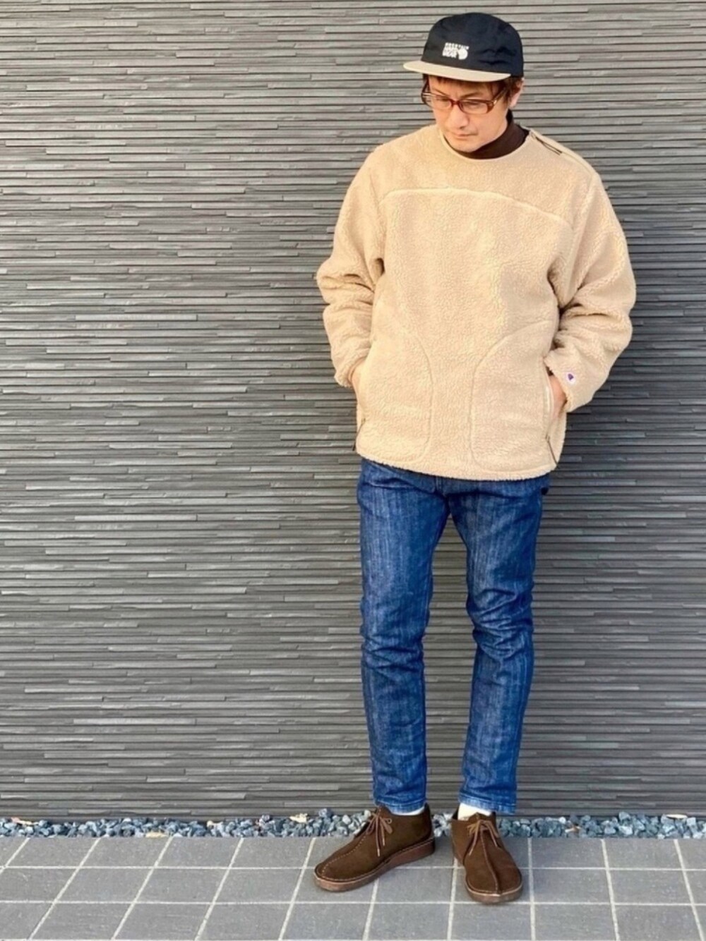 ベージュ系のスウェット、ブラウン系のTシャツ/カットソー、ブルー系のデニムパンツを着用したメンズの秋コーディネートの1枚目の写真