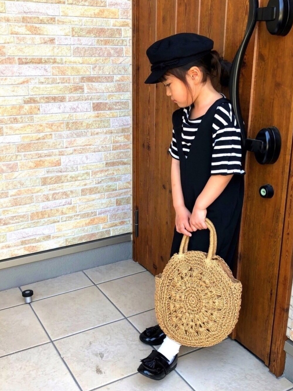 ホワイト系のTシャツ/カットソー、ブラック系のサロペット/オーバーオール、ブラウン系のショルダーバッグを着用したキッズの春コーディネートの1枚目の写真