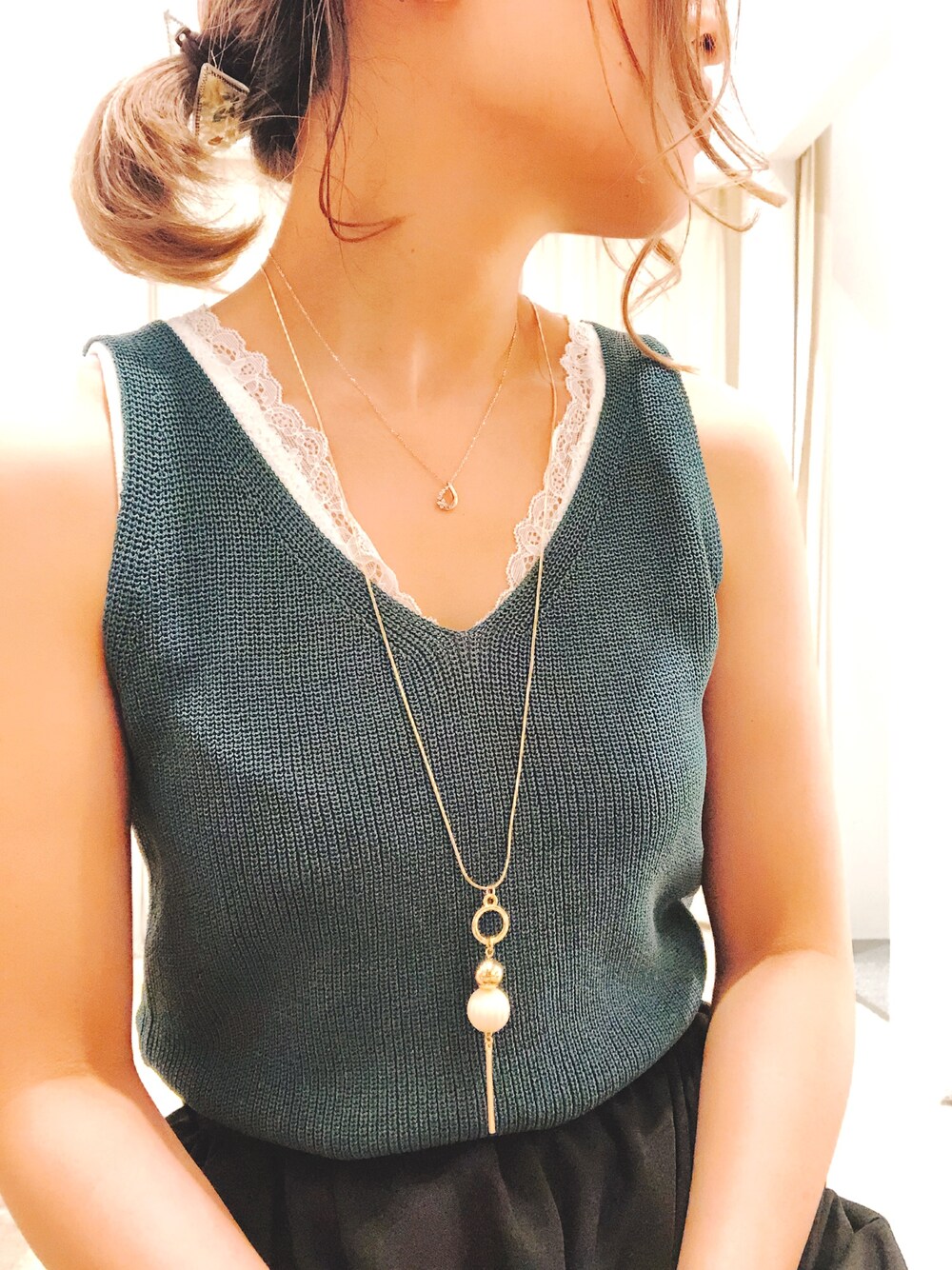 グリーン系のニット/セーター、ホワイト系のタンクトップ、ゴールド系のネックレスを着用したレディースの夏コーディネートの1枚目の写真