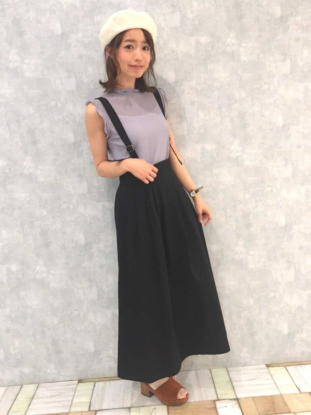 ブラック系のジャンパースカート、ブルー系のTシャツ/カットソー、ブラウン系のサンダルを着用したレディースの春コーディネートの1枚目の写真