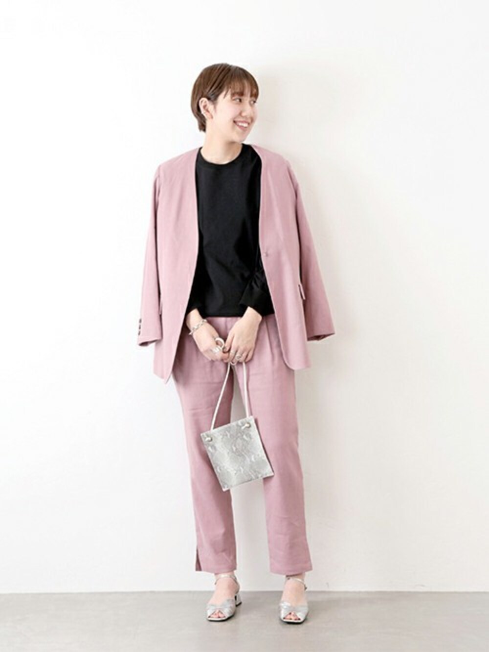 ピンク系のノーカラージャケット、ピンク系のその他パンツ、ブラック系のTシャツ/カットソーを着用したレディースの冬コーディネートの1枚目の写真