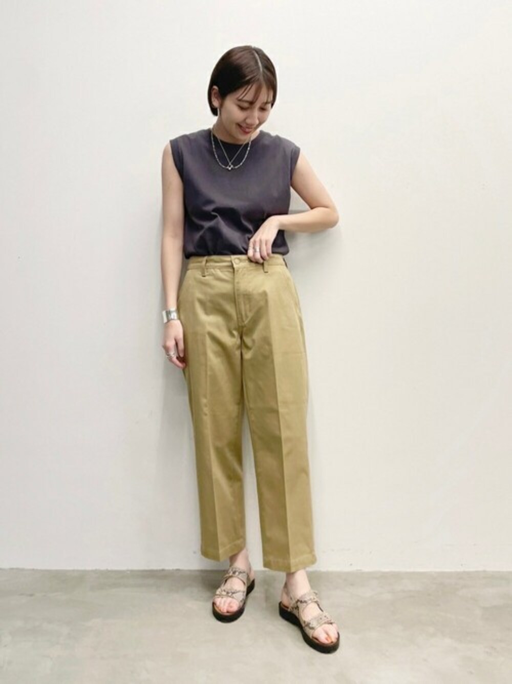 ベージュ系のその他パンツ、ブラック系のTシャツ/カットソー、ブラウン系のサンダルを着用したレディースの春コーディネートの1枚目の写真