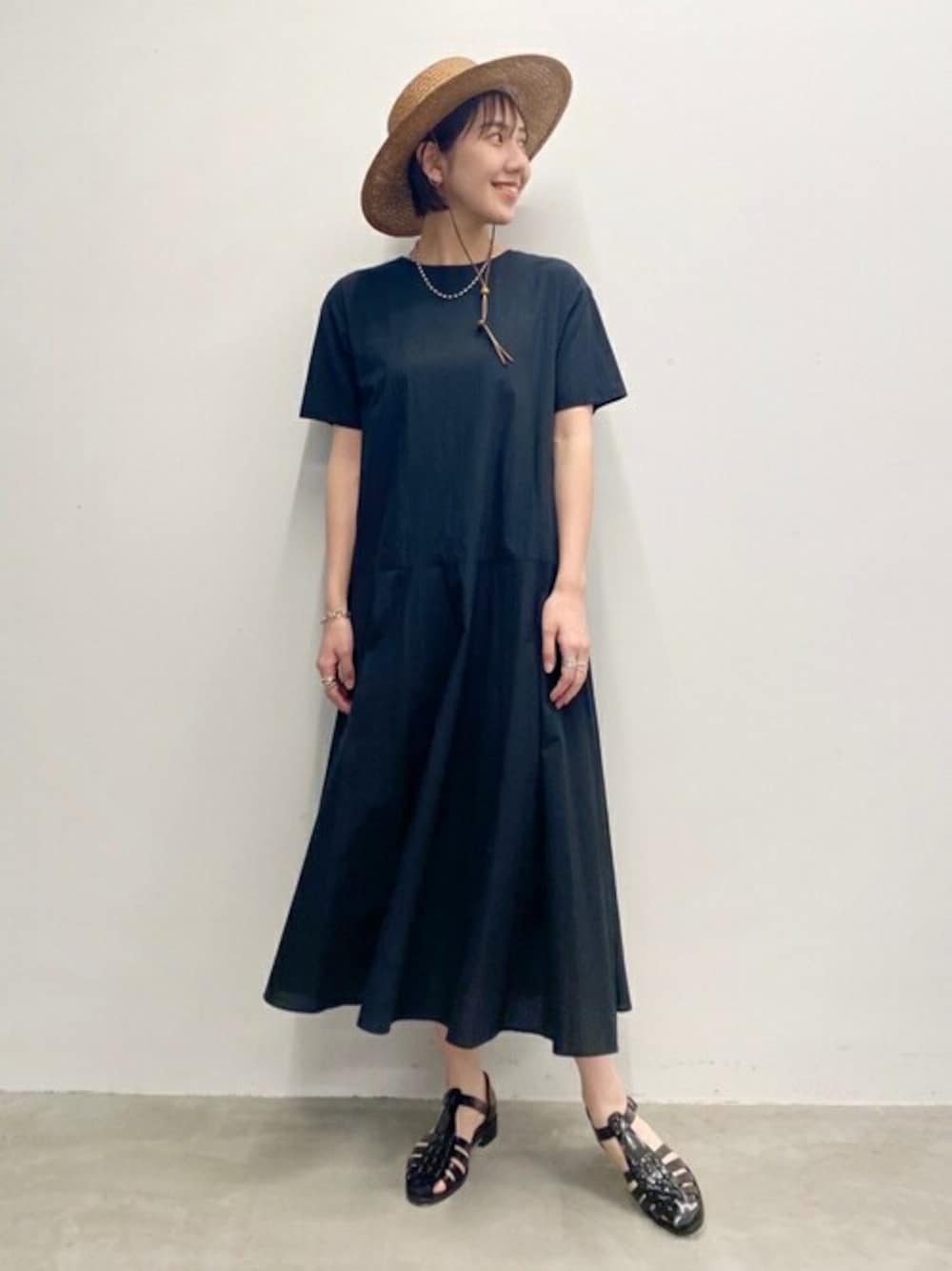 ブラック系のワンピース、ブラック系のサンダル、シルバー系のネックレスを着用したレディースの春コーディネートの1枚目の写真