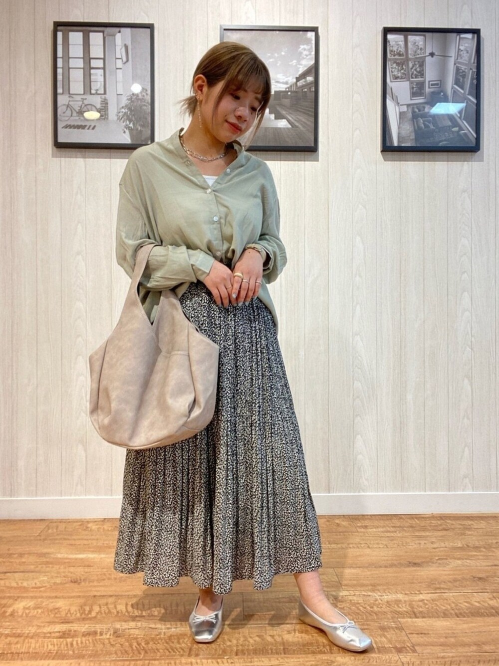 ブラック系のスカート、シルバー系のパンプス、ベージュ系のトートバッグを着用したレディースの春コーディネートの1枚目の写真