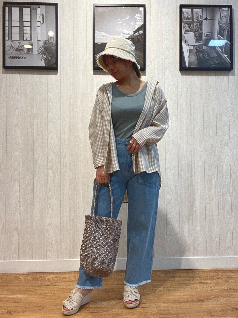 グリーン系のタンクトップ、ベージュ系のシャツ/ブラウス、ブルー系のデニムパンツを着用したレディースの春コーディネートの1枚目の写真