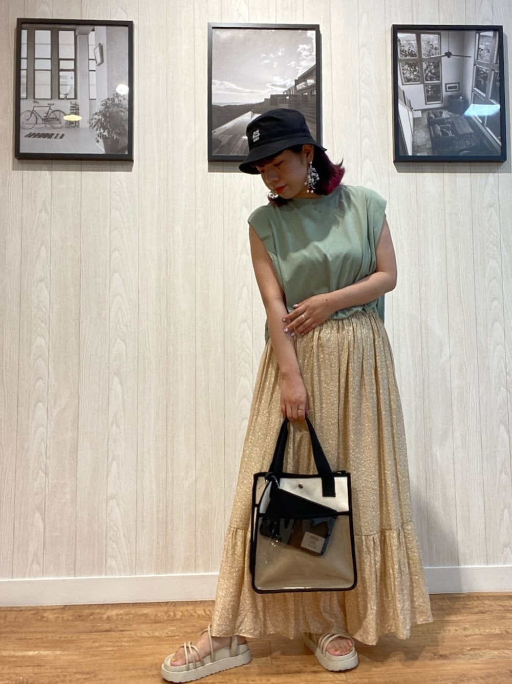 グリーン系のTシャツ/カットソー、イエロー系のスカート、ホワイト系のサンダルを着用したレディースの夏コーディネートの1枚目の写真