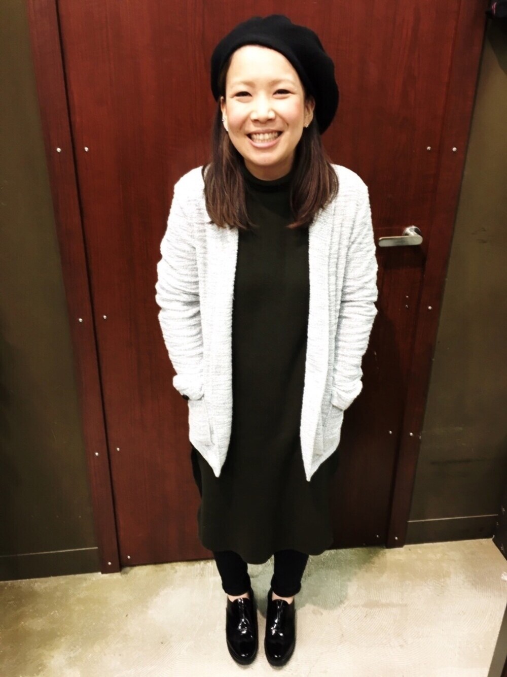 ホワイト系のその他アウター、グリーン系のワンピース、ブラック系のブーツを着用したレディースの冬コーディネートの1枚目の写真